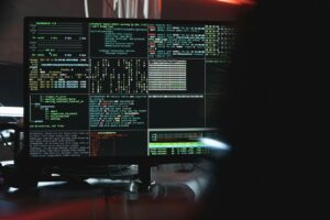 Gros plan d'un écran d'ordinateur affichant des données et du code de cybersécurité, indiquant un piratage ou une programmation du système.