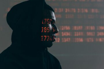 Gros plan d'un écran d'ordinateur affichant des données et du code de cybersécurité, indiquant un piratage ou une programmation du système.
